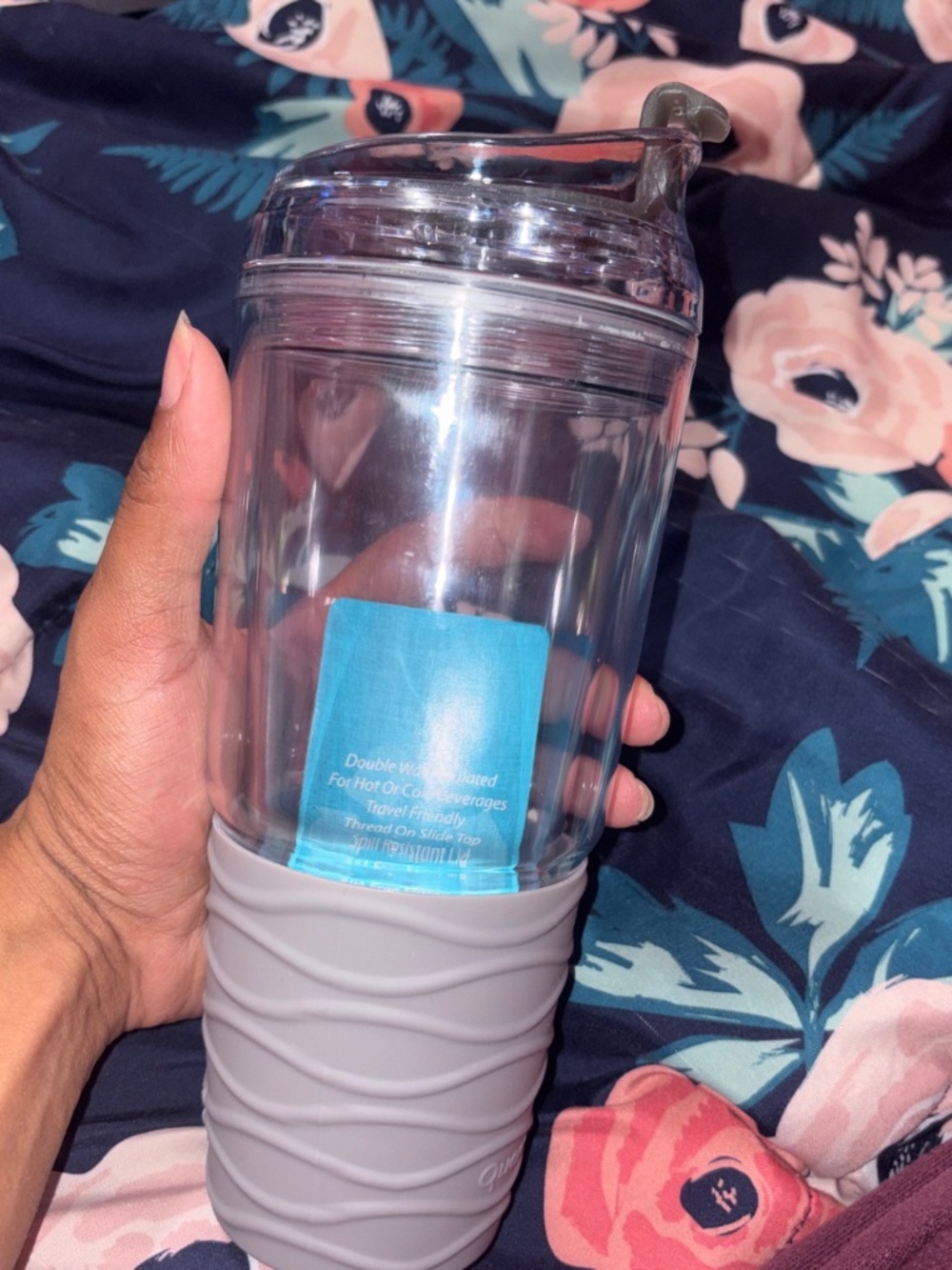 Clear glass water bottle with a gray silicon grip